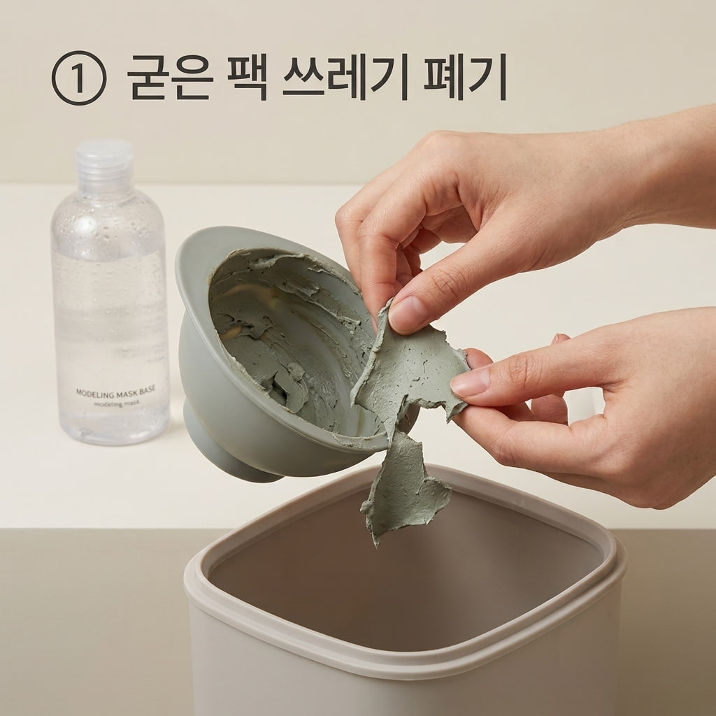 굳은 모델링팩 찌꺼기 일반 쓰레기 배출 하수구 배관 막힘을 방지하기 위해 두 손으로 실리콘 고무볼에 남은 굳은 모델링팩 찌꺼기를 깔끔하게 떼어내어 일반 쓰레기통에 버리는 모습.
