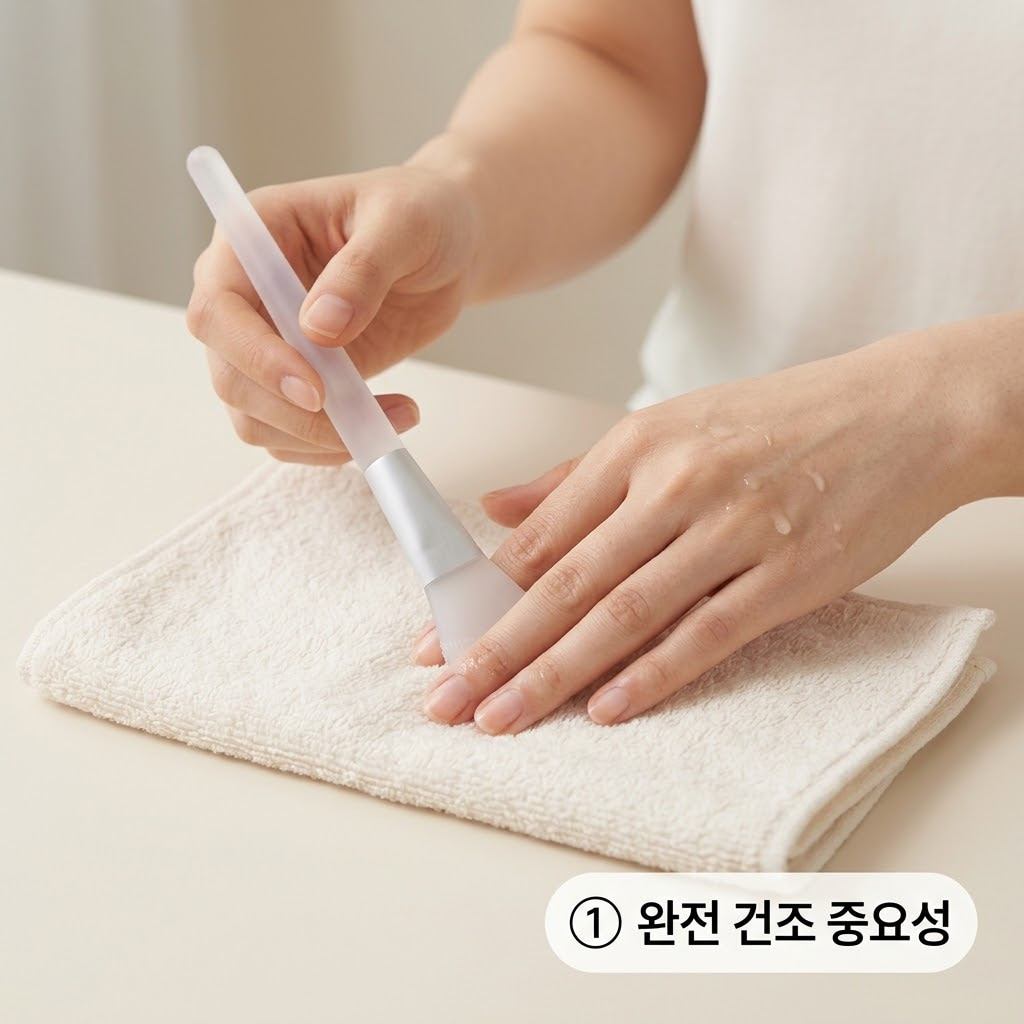 필오프팩 브러쉬 완전 건조를 위해 두 손으로 모 브러쉬를 마른 수건 위에 평평하게 눕히고 끝부분의 물기를 가볍게 눌러 빼내는 모습.