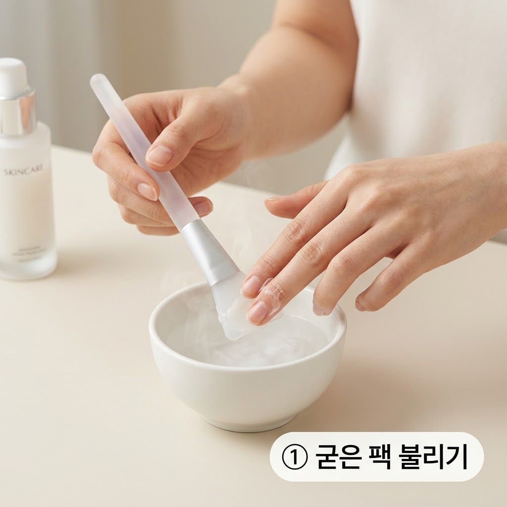 실리콘 브러쉬 굳은 팩을 안전하게 불리기 위해 두 손으로 미지근한 물에 브러쉬 표면을 적시며 손가락으로 조심스럽게 막을 밀어내는 모습.